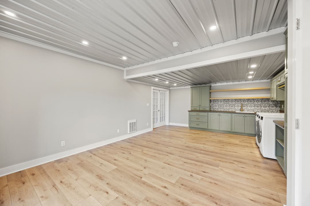 Renovated open-concept living space with modern kitchen and wood flooring.